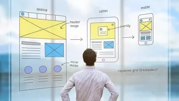 Man viewing website design sketches on transparent board.
