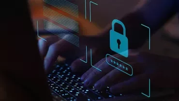 Person typing on a laptop with digital security overlay.