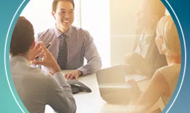 Business meeting with four people discussing around a table